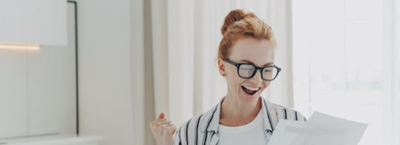 The Benefits of Paying Off Your Loans Early; a happy women looking at a letter