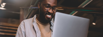  Impulsive Spending Dealing With Unhealthy Spending Habits; man smiling on laptop