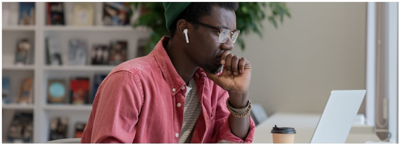 5 Signs You're Overwhelmed with Debt; a man looking at his laptop