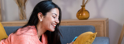 Woman smiling at phone after learning how to clear her loan faster