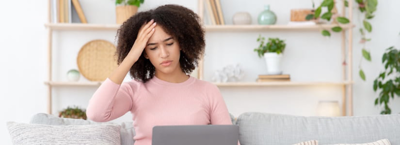 woman on laptop at home stressed with money problems