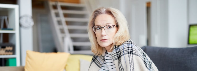 Woman sitting on sofa in endless debt