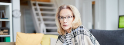 Woman sitting on sofa in endless debt