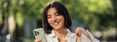 Woman looking at her phone, evaluating her credit score and credit history