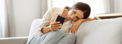 woman looking at phone understanding debt anxiety